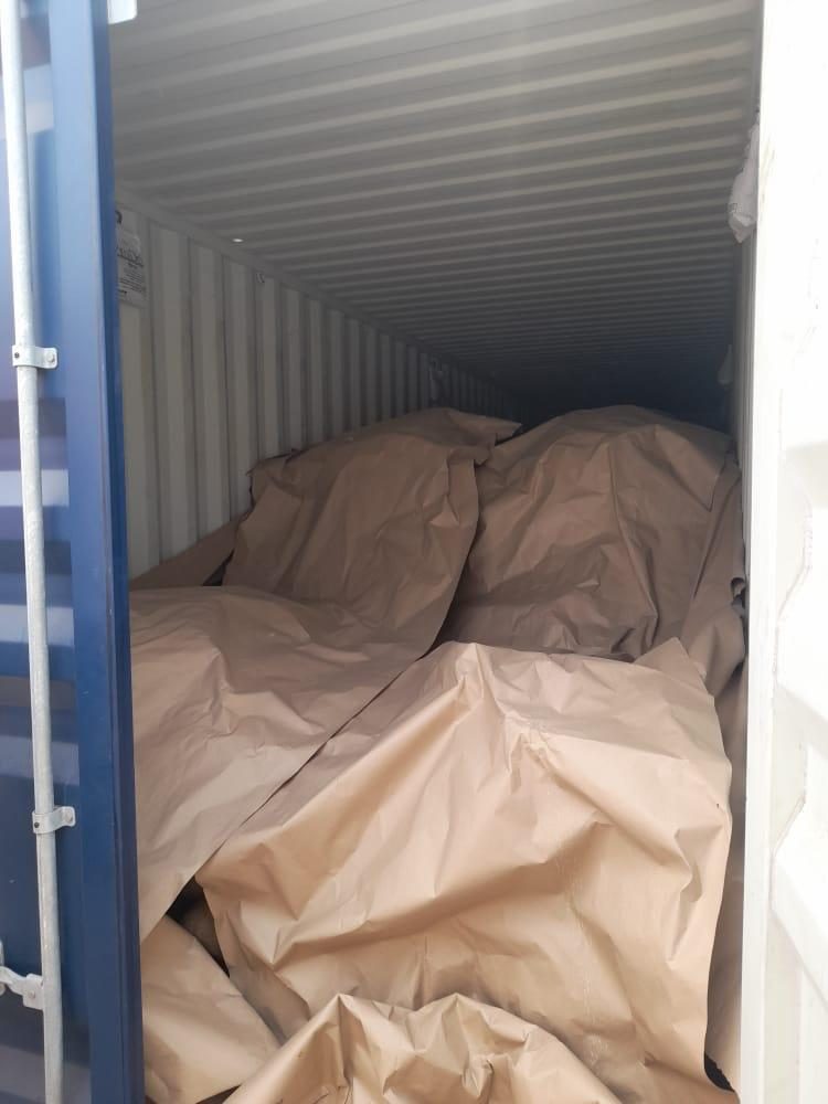 The open door of a shipping container loaded with wrapped cargo